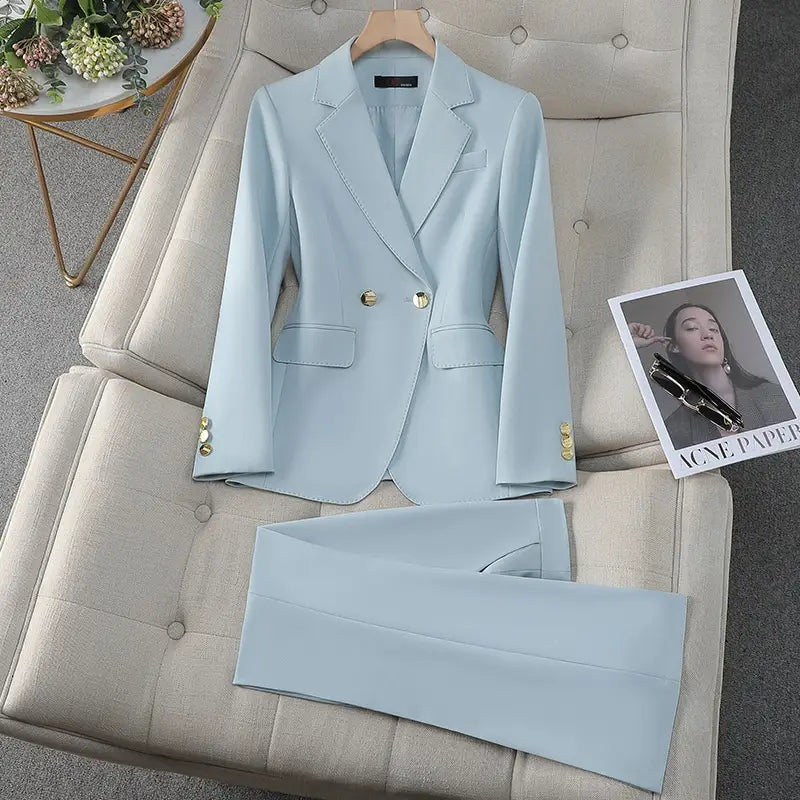 light blue tailored business suit with gold buttons featuring a double-breasted blazer and matching trousers displayed on a tufted beige couch, ideal for professional attire and contrasting with wine red suits in style and color.