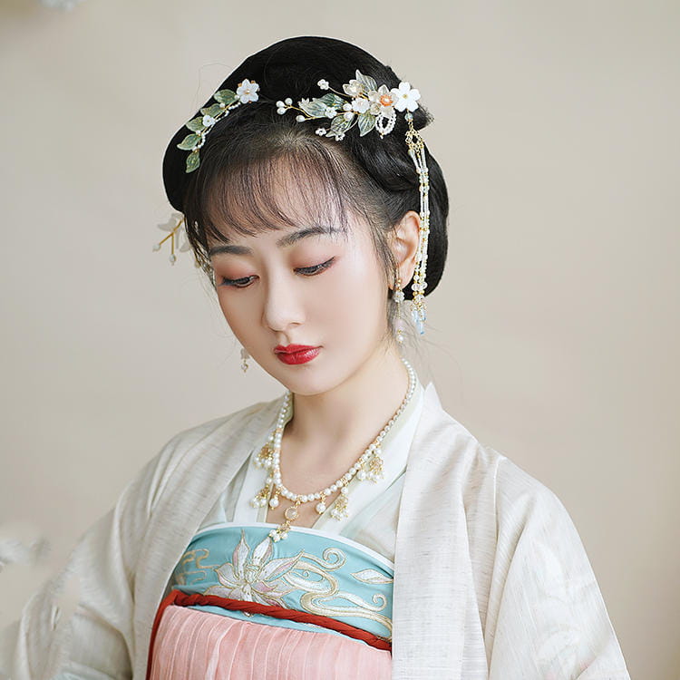 Elegant black hanfu ancient style handmade hairpiece adorned with delicate white and green floral embellishments and dangling gold chains in a style handmade hair crown.