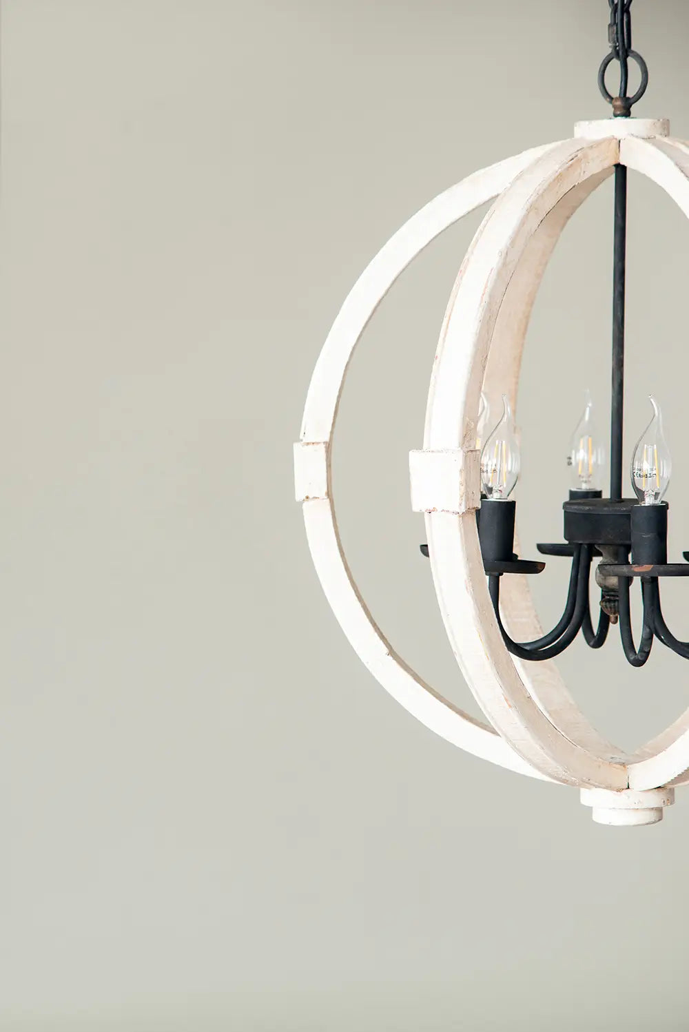 rustic white globe light wood chandelier featuring a white-painted wooden sphere with black metal arms and exposed bulbs as a wood chandelier centerpiece
