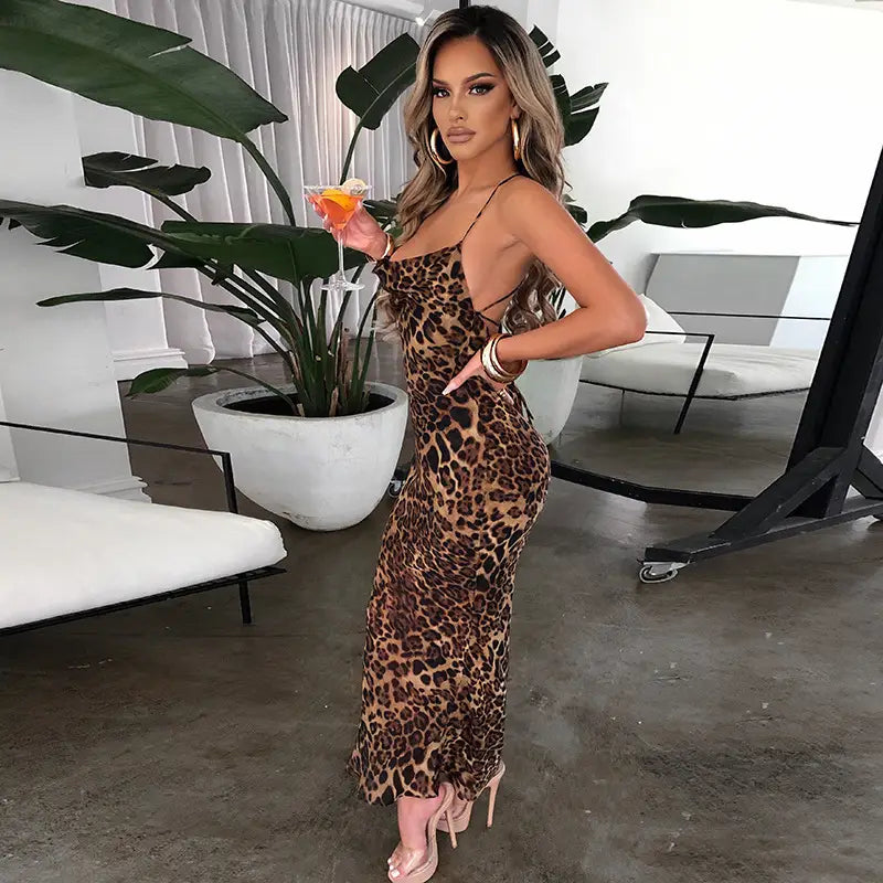 A form-fitting slim fit long dress featuring a leopard printed lace design with thin spaghetti straps and a ruffled hem.