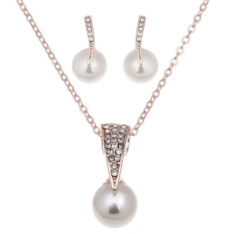 A delicate rose gold bride rhinestone pearl necklace set featuring a triangular pendant with sparkling crystals and a dangling white pearl paired with matching rhinestone pearl earrings.