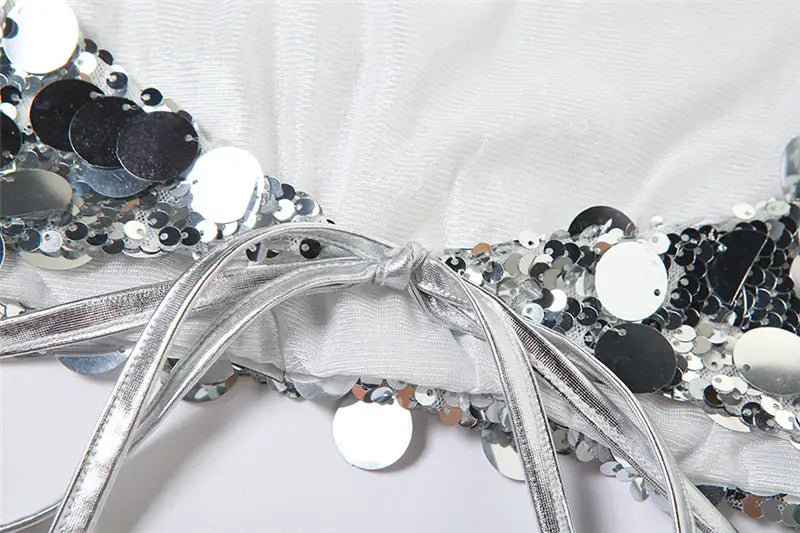 Silver halter backless sequined vest featuring a reflective silver sequined bodice with black and silver circular embellishments.