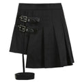 Black asymmetric pleated skirt with dark leg ring silver-toned buckle straps and matching ankle strap ring asymmetric design