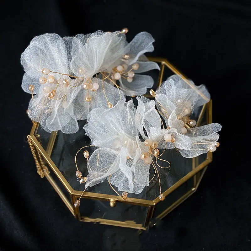 delicate white organza flower hairpins adorned with gold-toned beads and wirework in a tulle flower headband earring set