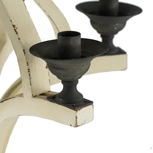 Black metal candle holder with a distressed white painted base as part of a 6 light wood chandelier for dining hall entrance.