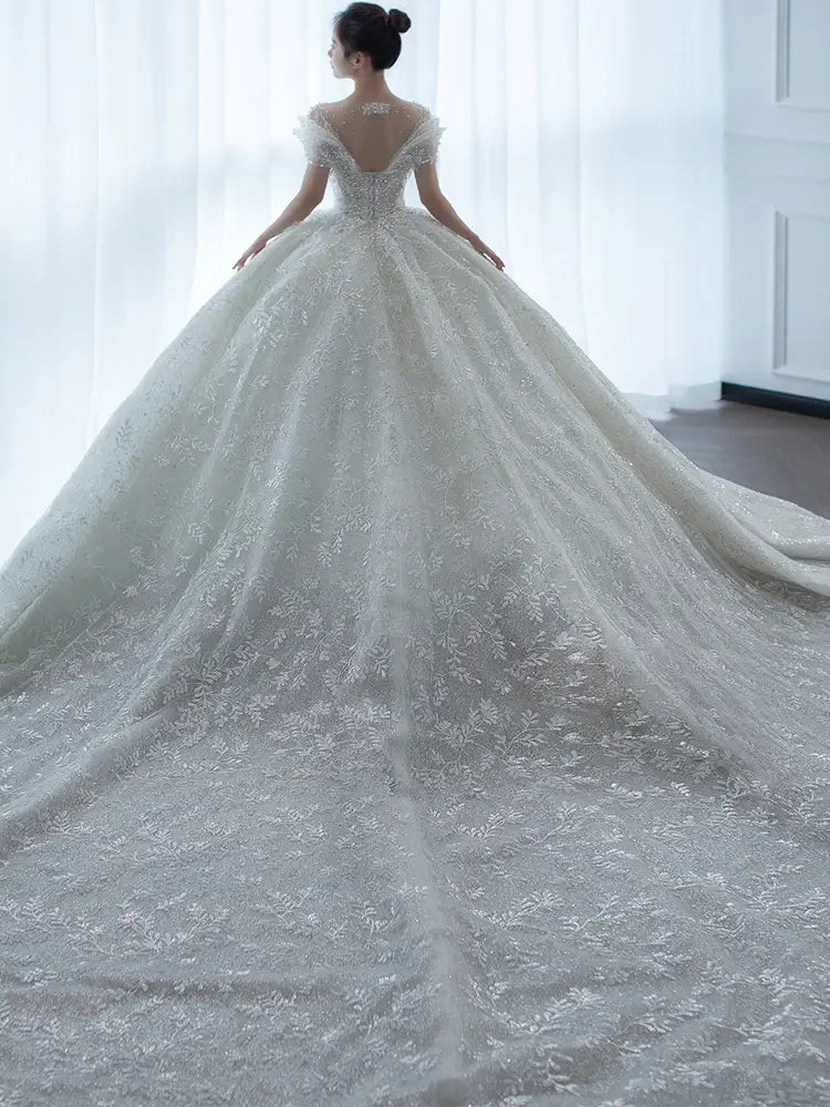 off shoulder lace wedding dress featuring a voluminous white lace fabric with an off the shoulder design and a long flowing train perfect for a level wedding dress piece set.