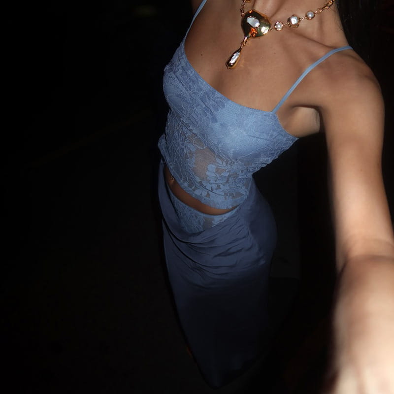 blue lace crop top with thin straps paired with a matching high-waisted skirt featuring lace backless tube design and sling stitching ruffle hip details in sage green.
