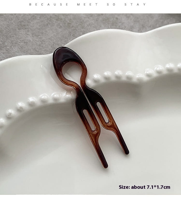 a sleek two-pronged tortoiseshell bun lazy updo gadget hair clip with a glossy finish and an elegant curved handle for easy head bun lazy styling
