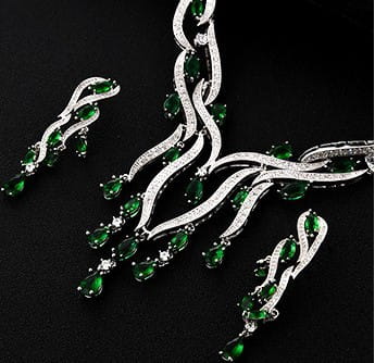emerald green crystal jewelry zircon jewelry set featuring teardrop gemstones set in a silver-toned flowing vine-inspired necklace and matching earrings.