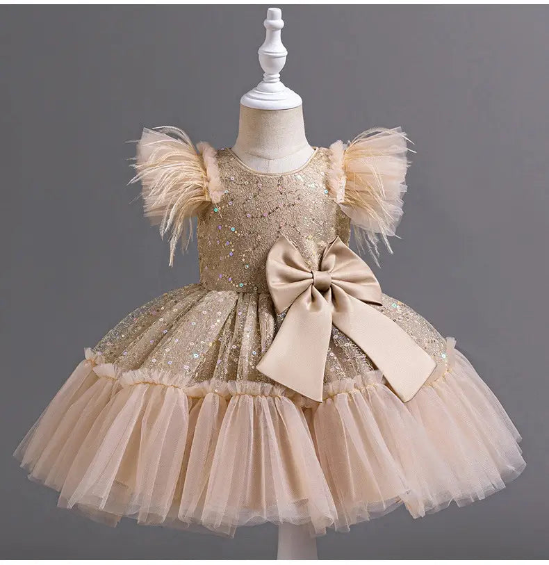 A shimmering gold sequined toddler wedding dress tulle with fluffy feathered sleeves, a large beige satin bow at the waist, and a soft layered dress tulle skirt summer.