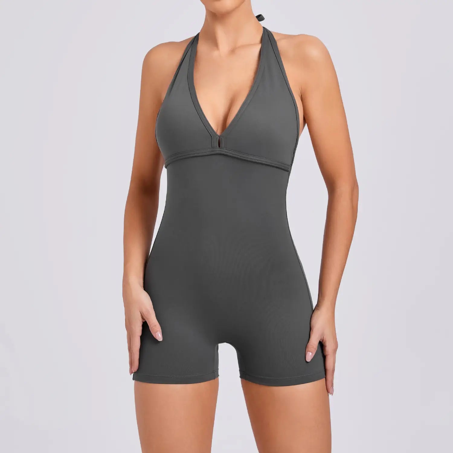 A sleek dark gray halter neck high elastic yoga romper with a flattering v-cut neckline and form-fitting one-piece bodysuit design.