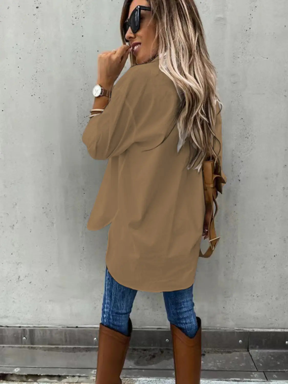 a tan long sleeve lapel coat with a loose fit and a slightly asymmetrical hemline modeled as part of a red loose long sleeve lapel button down shirt collection