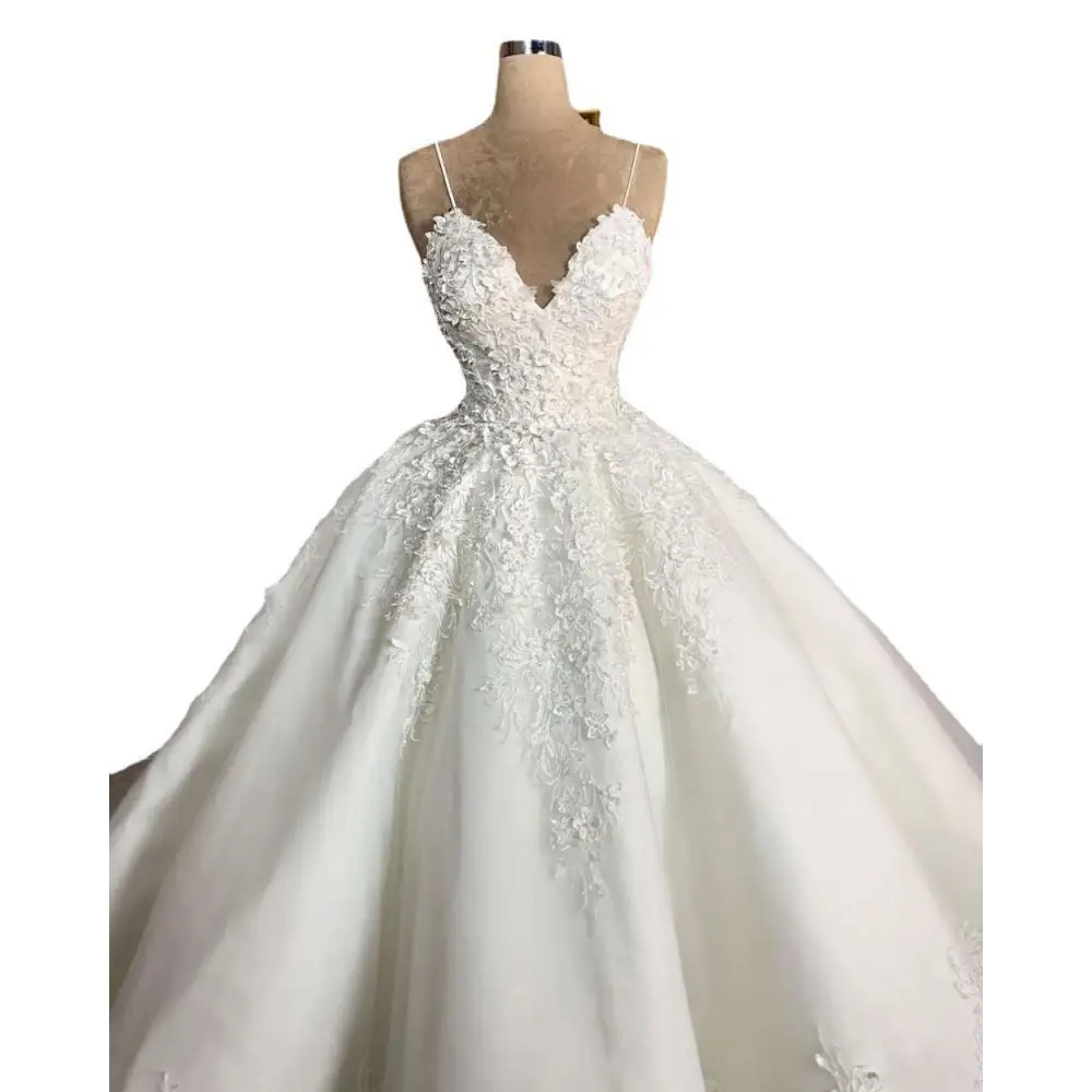 A white lace wedding dress with deep v-neck lace and voluminous skirt on a mannequin embodying romantic aura