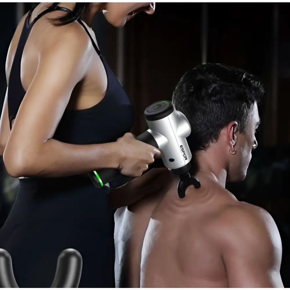 Silver and black handheld deep vibration shock massage gun with textured grip and interchangeable massage heads
