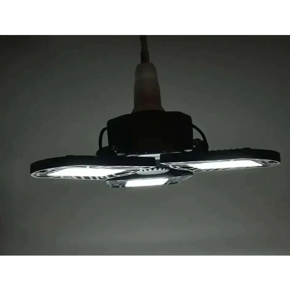 Black foldable deformable lamp garage light with three illuminated adjustable panels and a power cord hanging from the top
