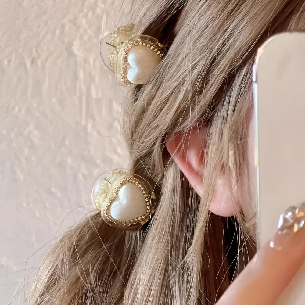 Heart-shaped hair clips with delicate gold diamond frames and love pearl heart centers in gold diamond love style