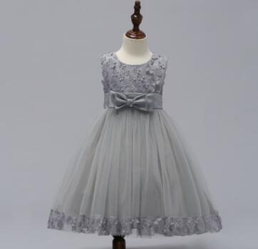 A delicate gray lace wedding dress with a fitted bodice and flowing tulle skirt adorned with floral embroidery at the neckline and hem perfect for a flower girl or bridal party.