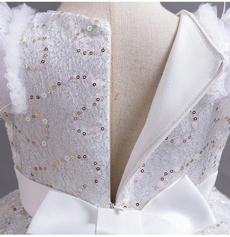 a delicate white lace wedding dress tulle with shimmering silver sequins in soft pastel hues and a matching satin bow at the waist ideal for summer occasions.