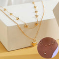 Gold-toned double layer heart pendant fine chain necklace with delicate links and spherical bead accents