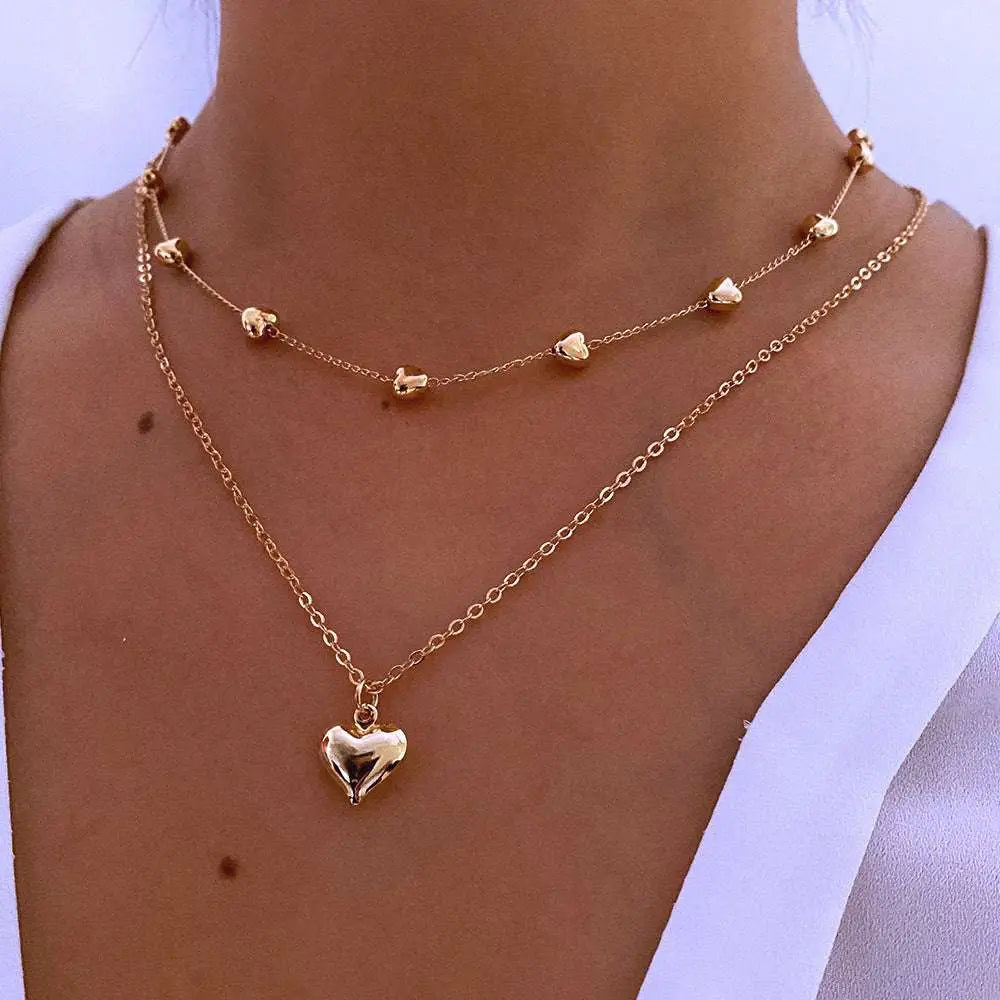Gold-toned double layer heart pendant fine chain necklace featuring delicate chains and small heart charms