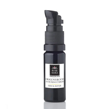 Black glass bottle with black pump dispenser labeled rose mira organics dragon’s blood antioxidant serum for firm and repair