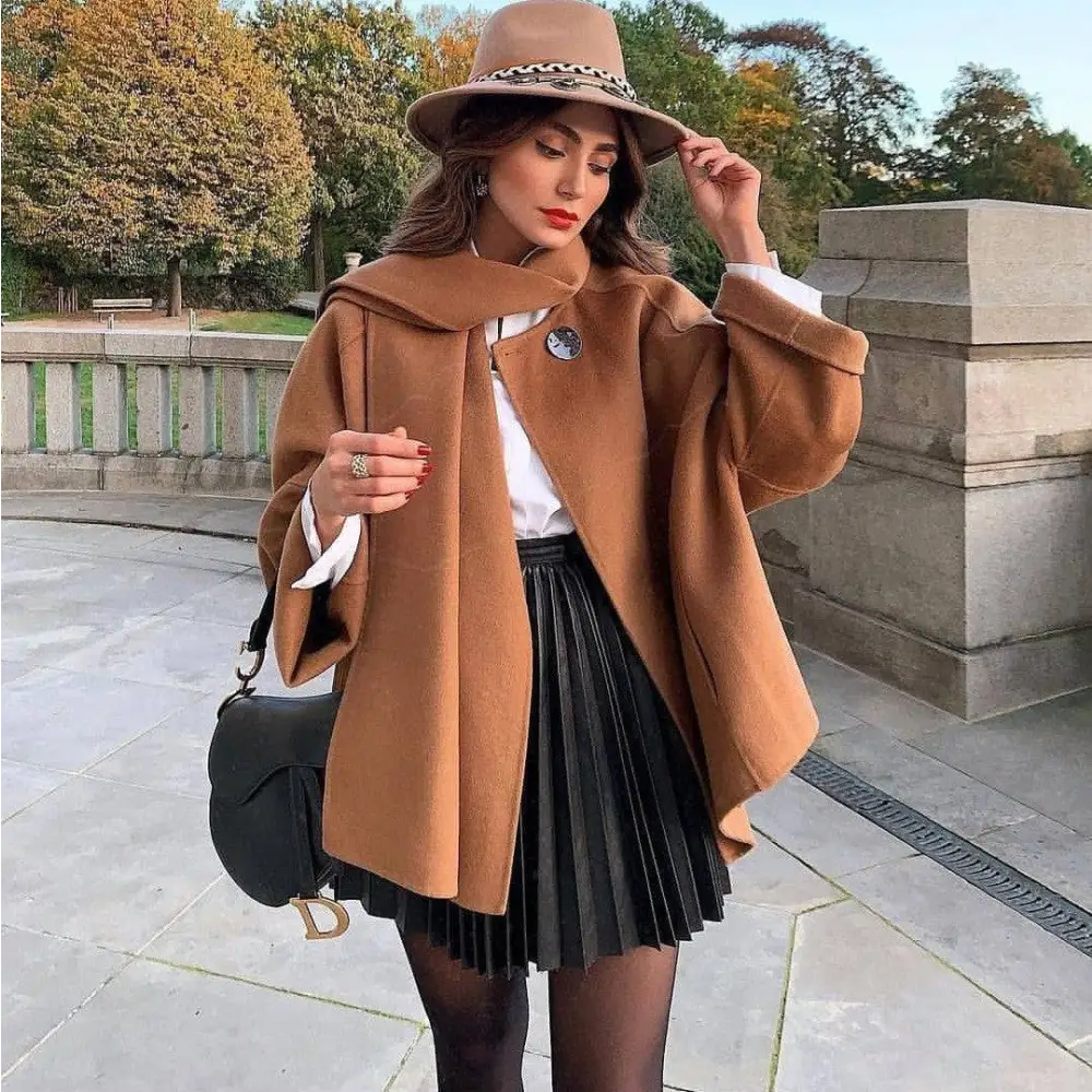 Black quilted leather gucci mini crossbody bag with gold-tone gg logo and chain strap styled with draped pleated knitted mini skirt