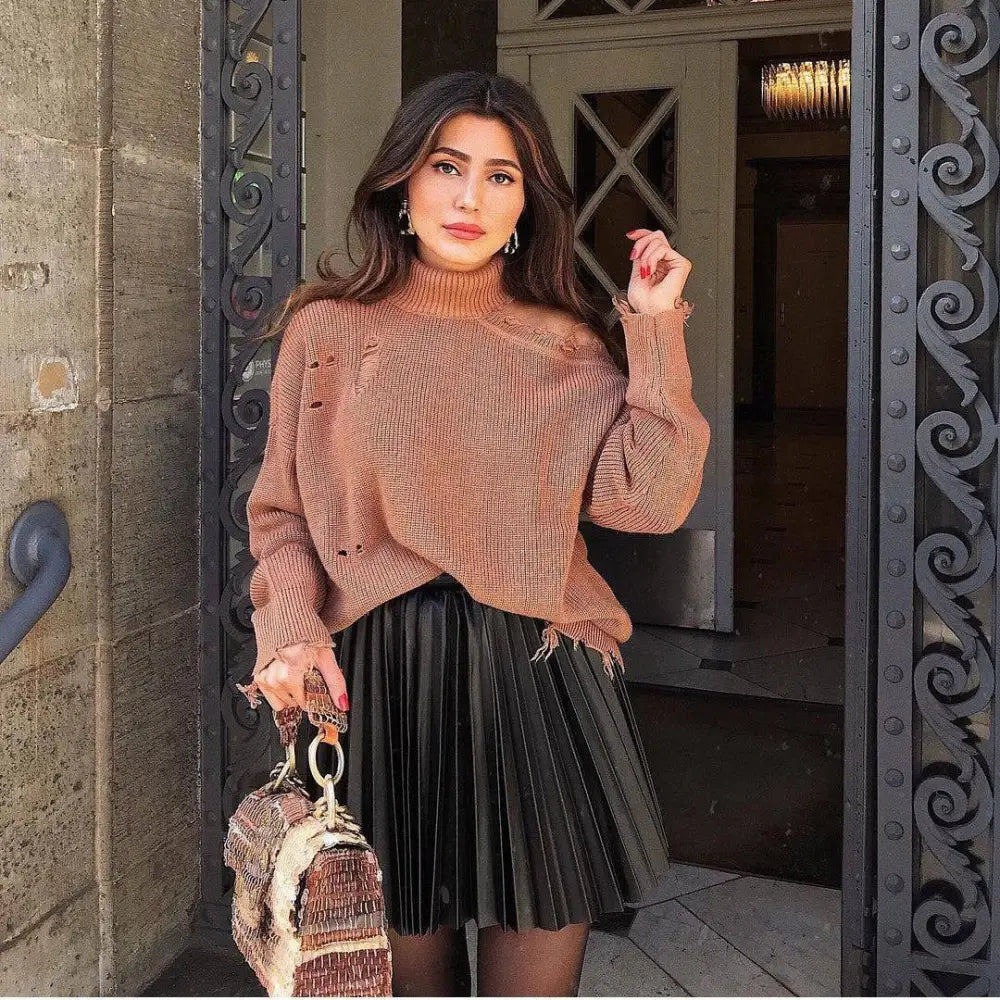 Earth-toned textured knit sweater with distressed holes and frayed edges complements draped pleated knitted mini skirts