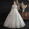 A woman wearing a dream slim sleeve lace ivory wedding gown with three quarter sleeves and a large size tulle skirt