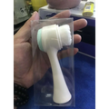 White plastic dual sided silicone beauty skin care face wash brush with light green textured grip and soft bristles