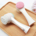 White dual sided silicone beauty skin care face wash brush with pink textured head and soft bristles