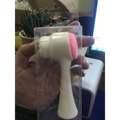 Dual sided silicone beauty skin care face wash brush in pink and white silicone in clear plastic packaging