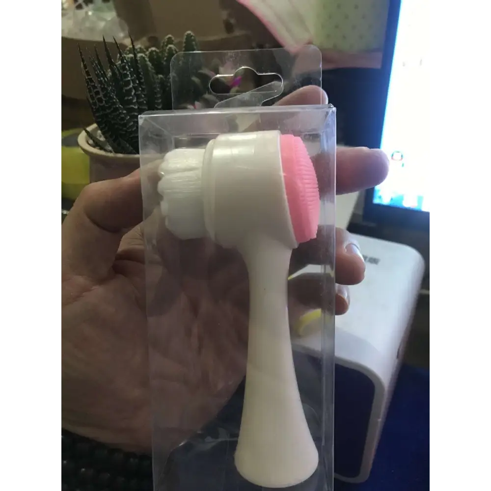 Dual sided silicone beauty skin care face wash brush in pink and white silicone in clear plastic packaging
