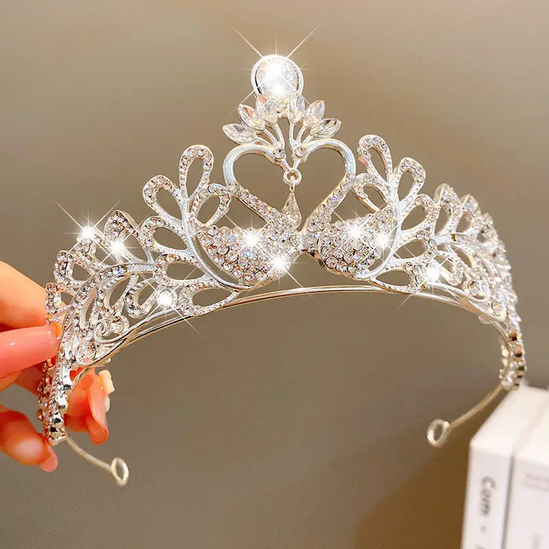 A sparkling silver crown headband from sweet fashion jewelry featuring intricate heart and leaf designs embellished with clear crystals as elegant hair accessories.