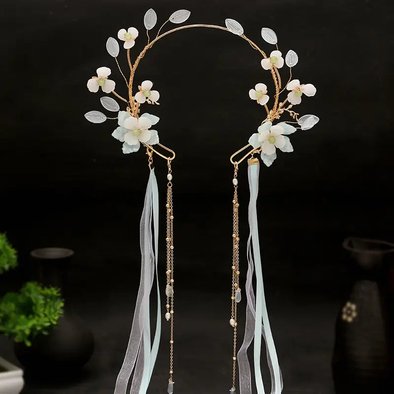 Elegant gold-toned floral hanfu tassels girls fashion headband adorned with delicate white flowers, translucent leaves, and flowing light blue ribbons for girls fashion.