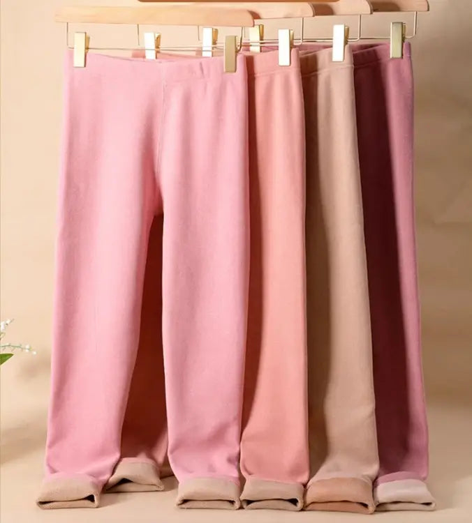 a set of four women’s warm cashmere fleece lined thermal leggings in soft pastel pink and mauve shades with matching elastic waistbands and ribbed cuffs for warm cashmere winter wear.