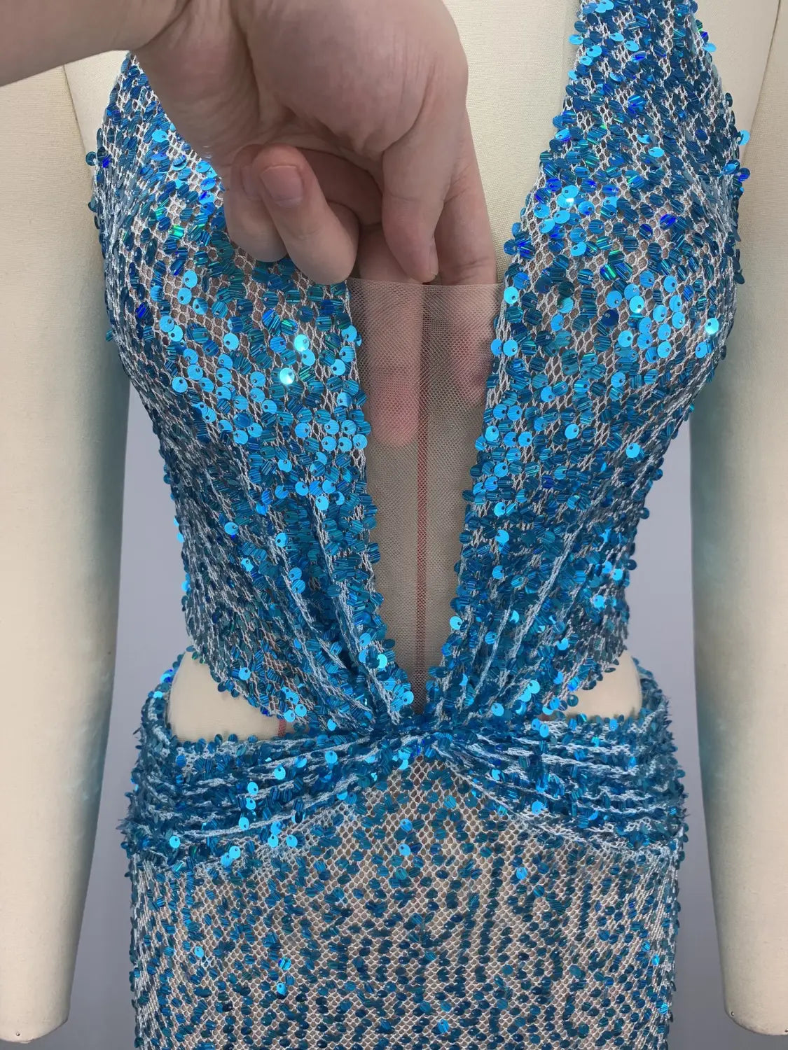 A shimmering blue sequined slimming party stage host mermaid gown with a deep v-neckline and intricate beaded detailing.