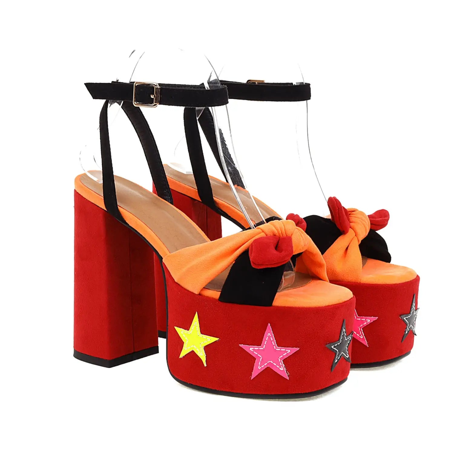 Red star appliqué chunky high heel platform sandals in red with orange and black accents featuring yellow pink and silver star decorations and decorative bows on the toe strap.