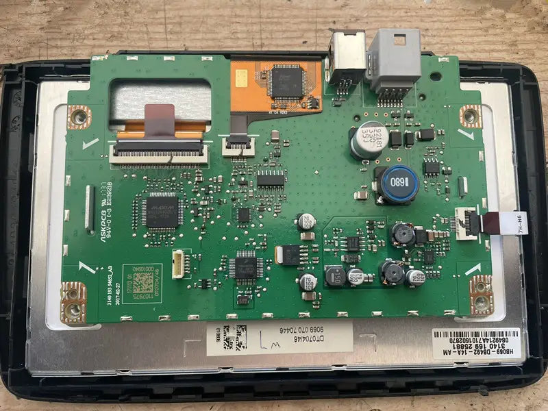green circuit board with electronic components and barcode label on the back side of an original car exterior touch screen replacement for car exterior screen repair