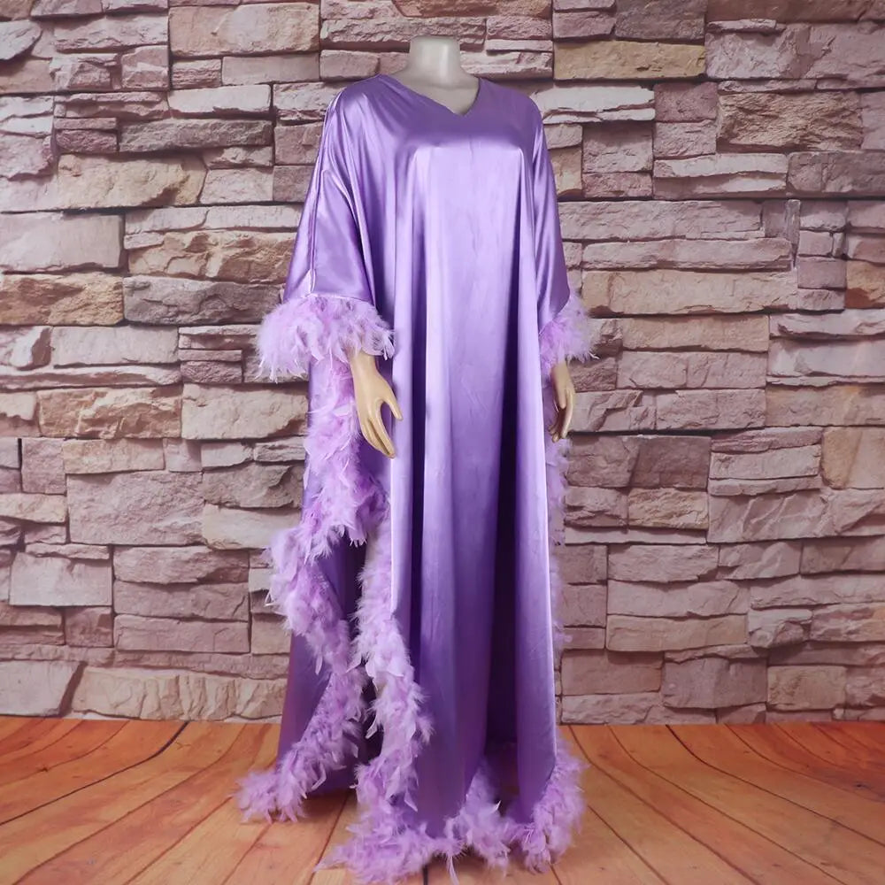 A flowing lavender satin abaya with feather trim along the sleeves and hem showcasing a loose dress luxury fully surrounded by elegant details.