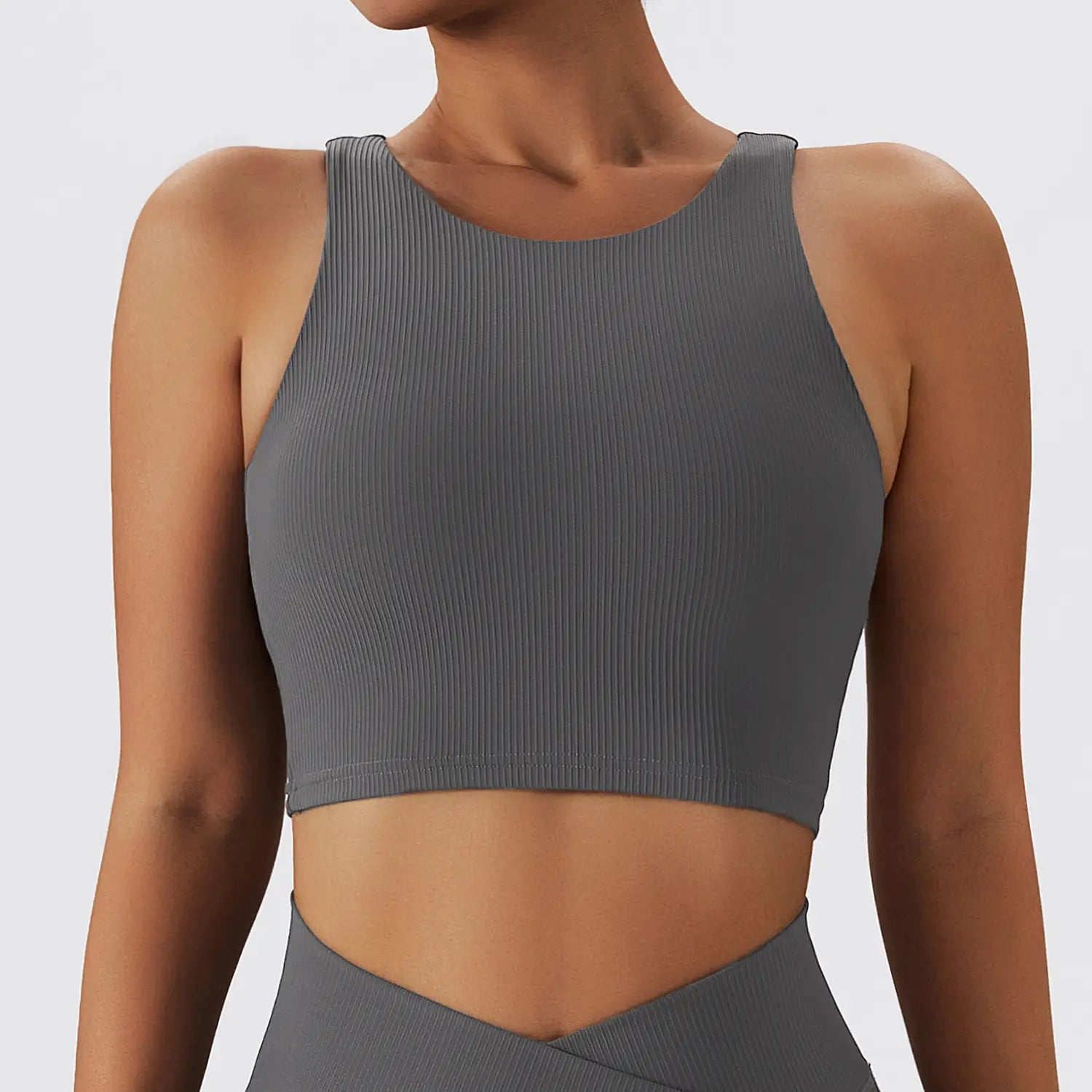 Gray ribbed crop top with a round neckline and shoulder straps designed as a quick dry breathable running sports bra for running sports activities.