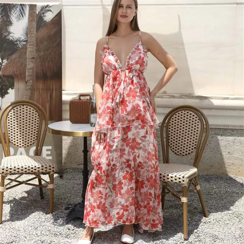A flowing tiered maxi fashion simple dress in vibrant coral and white floral print with delicate ruffled straps.