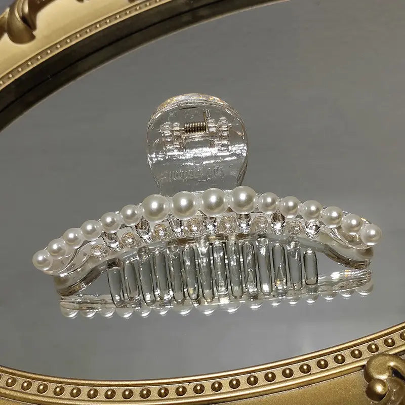 Transparent pearl grab clip featuring a clear crystal hair claw adorned with a row of white pearls and sparkling rhinestones for a clip gentle transparent look.
