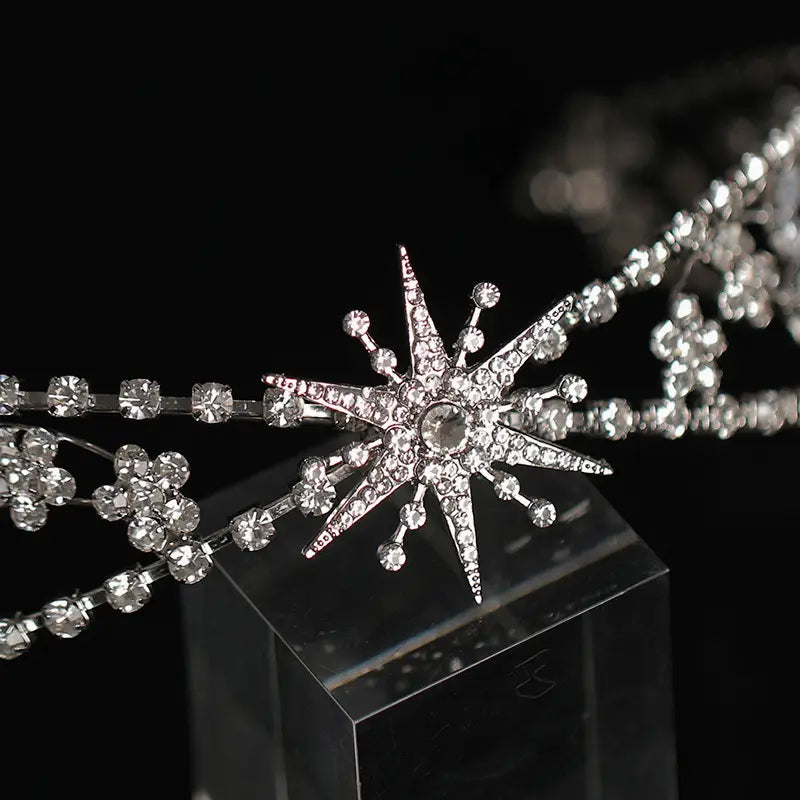 A sparkling silver bridal crown headdress adorned with clear rhinestones and delicate floral crystal accents featuring headdress rhinestone zircon details.