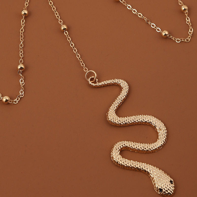 Bohemian boho gold big snake leg chain jewelry featuring a gold-toned snake pendant with a textured scaly surface and small black eyes.