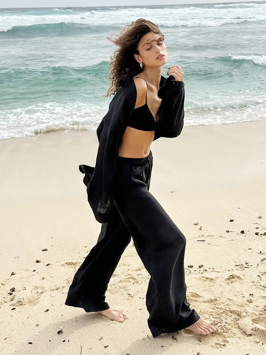 black satin wide-leg pants with relaxed fit and elastic waistband paired with white linen long sleeve cotton shirt trousers suit