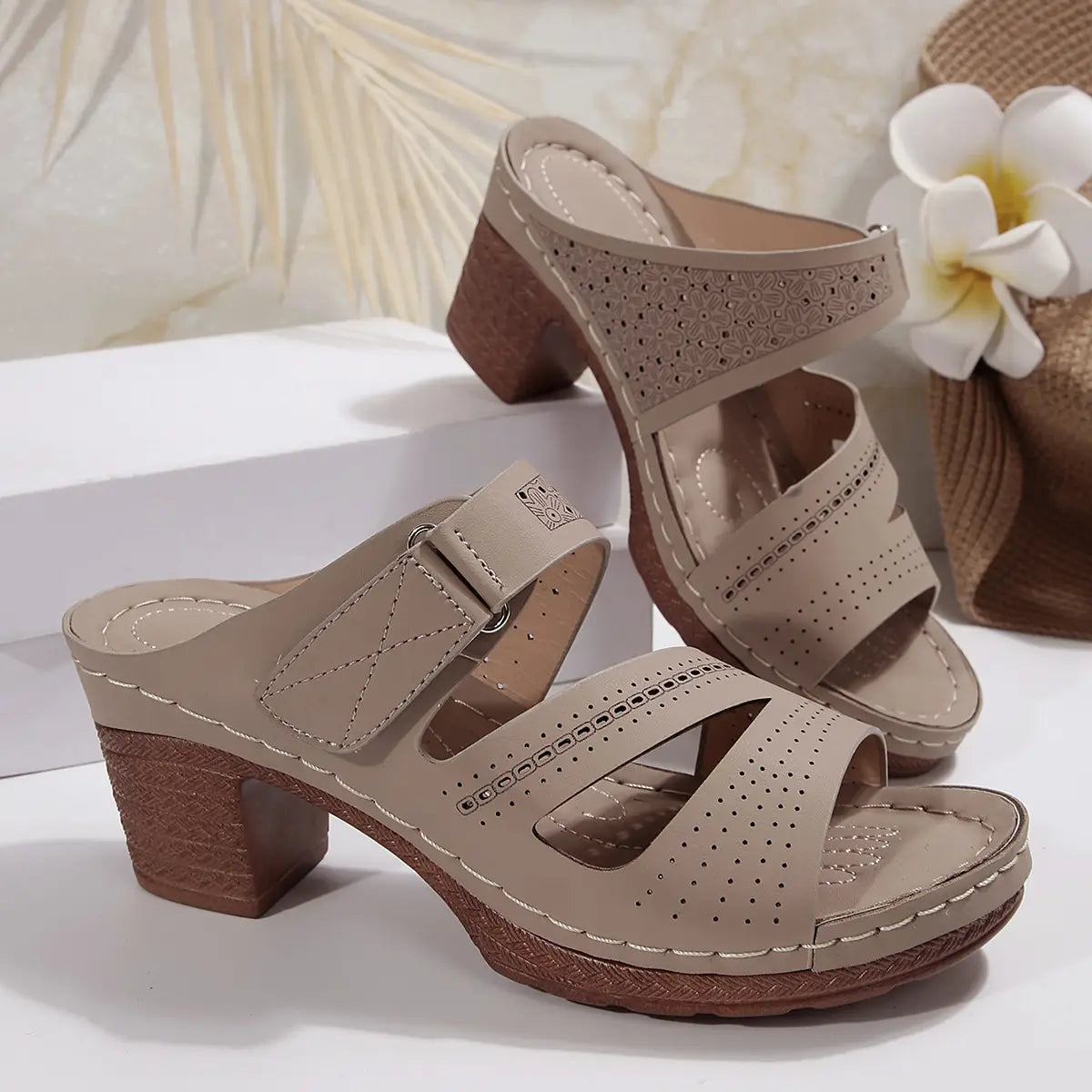 Beige leather mule sandals with perforated straps and a textured block heel designed as tan leather summer casual chunky shoes.