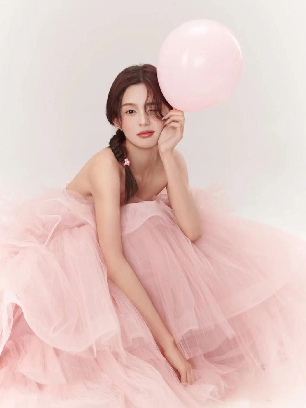 A soft pink strapless ball gown dress with voluminous tiered tulle layers from the dress fairy temperament temperament main yarn collection.