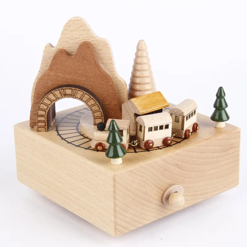 A diy dancing music box made of light wood features a miniature locomotive with red wheels green pine trees and an arched mountain tunnel in a christmas train toy design.