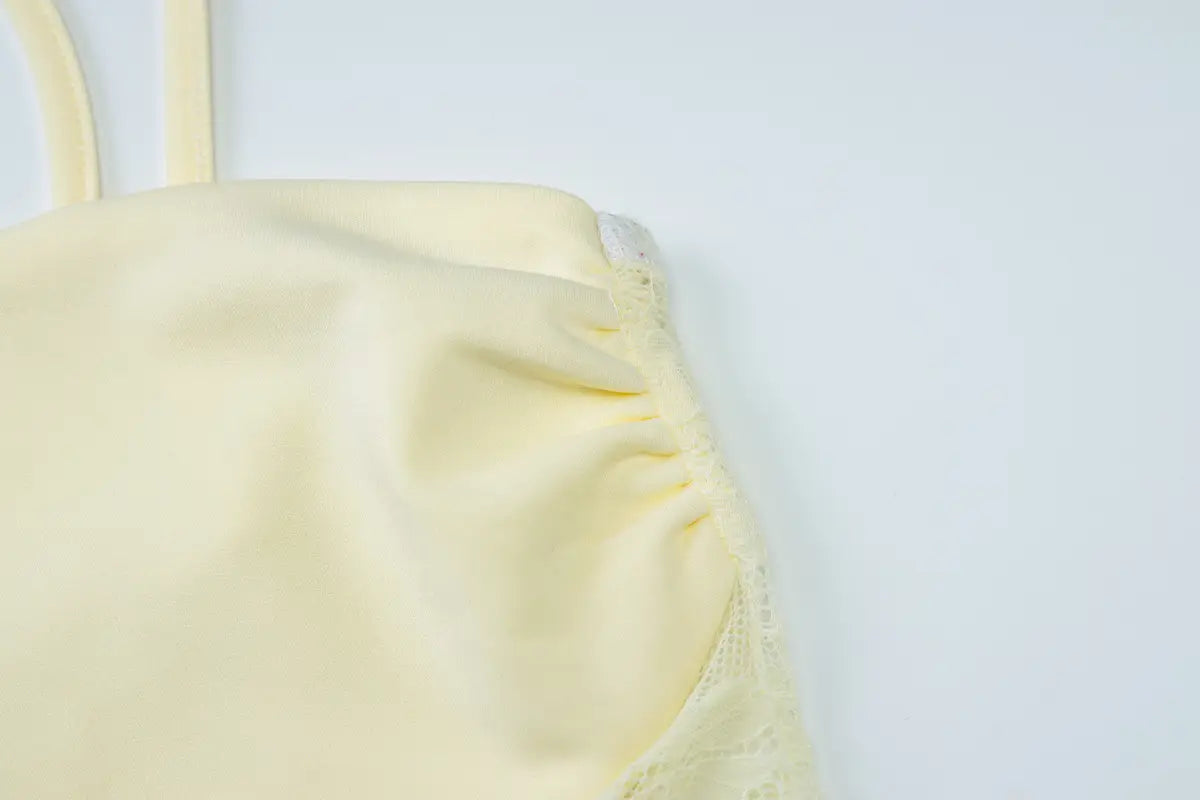a pale yellow soft fabric top with delicate ruching along the neckline and thin straps complementing a burgundy satin y2k lace suspender dress.