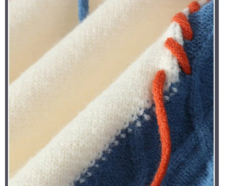 A cozy blue and white knitted ins colorblock pullover sweater with vibrant orange stitching along the seam designed for pullover sweater winter fashion.